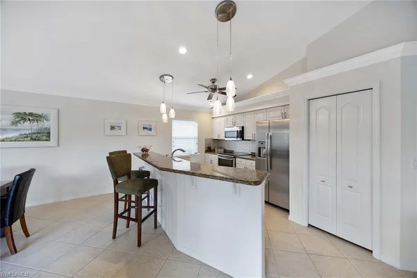 a kitchen with kitchen island a sink counter and chairs