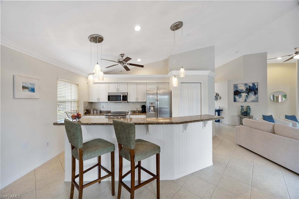 8468 Indian Wells Way Naples, FL 34113 - Photo 14 of 40 a large kitchen with a table and chairs in it
