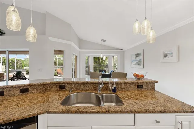 a kitchen with granite countertop a sink and a large window