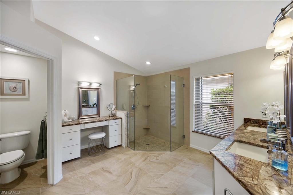 8468 Indian Wells Way Naples, FL 34113 - Photo 20 of 40 a spacious bathroom with a granite countertop double vanity sink a mirror and a shower