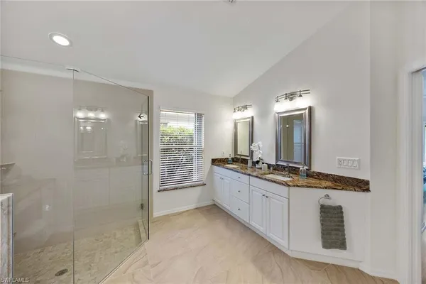 a large bathroom with a granite countertop sink a mirror and a shower