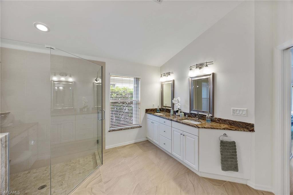 8468 Indian Wells Way Naples, FL 34113 - Photo 21 of 40 a large bathroom with a granite countertop sink a mirror and a shower
