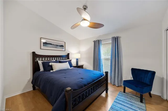 a bedroom with a bed wooden floor and window
