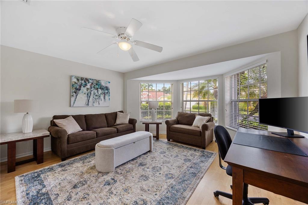8468 Indian Wells Way Naples, FL 34113 - Photo 23 of 40 a living room with furniture and a flat screen tv