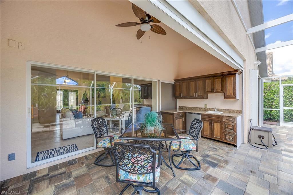 8468 Indian Wells Way Naples, FL 34113 - Photo 33 of 40 a living room with fireplace furniture and a floor to ceiling window