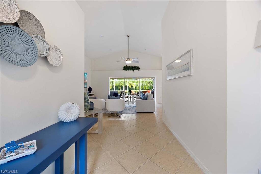 8468 Indian Wells Way Naples, FL 34113 - Photo 5 of 40 a hallway with a table and a couch