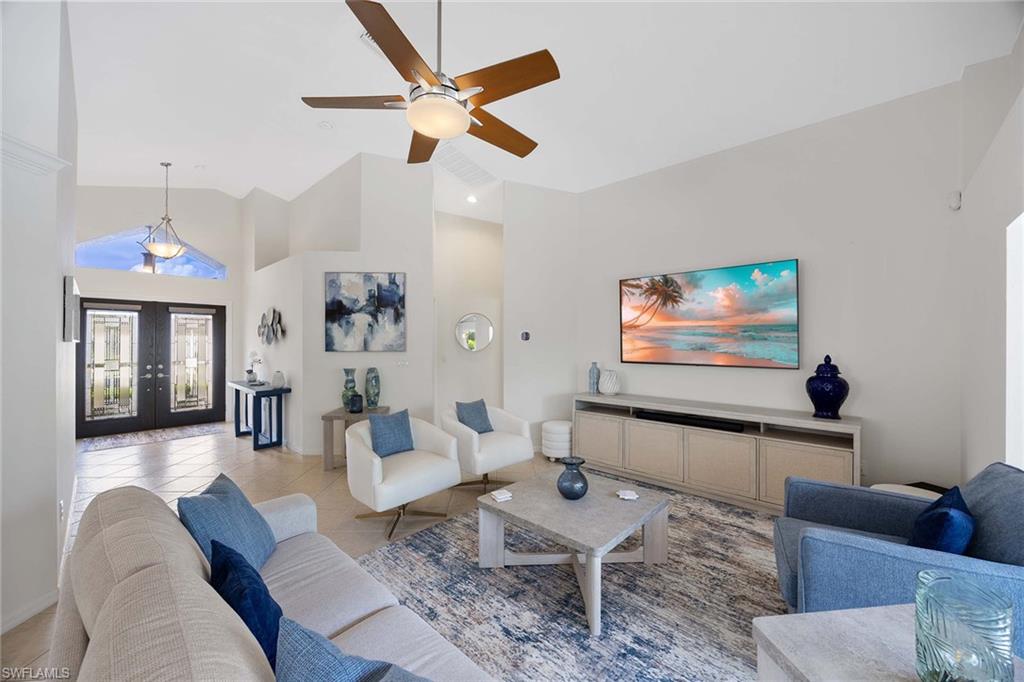 8468 Indian Wells Way Naples, FL 34113 - Photo 9 of 40 a living room with furniture and a flat screen tv
