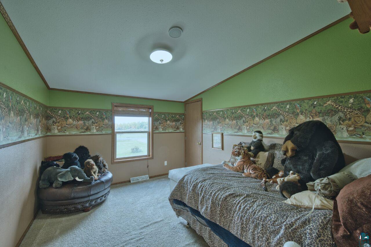 3360 North Leighton Road Hibbing, MN 55746 - Photo 25 of 60 Carpeted bedroom featuring vaulted ceiling and crown molding