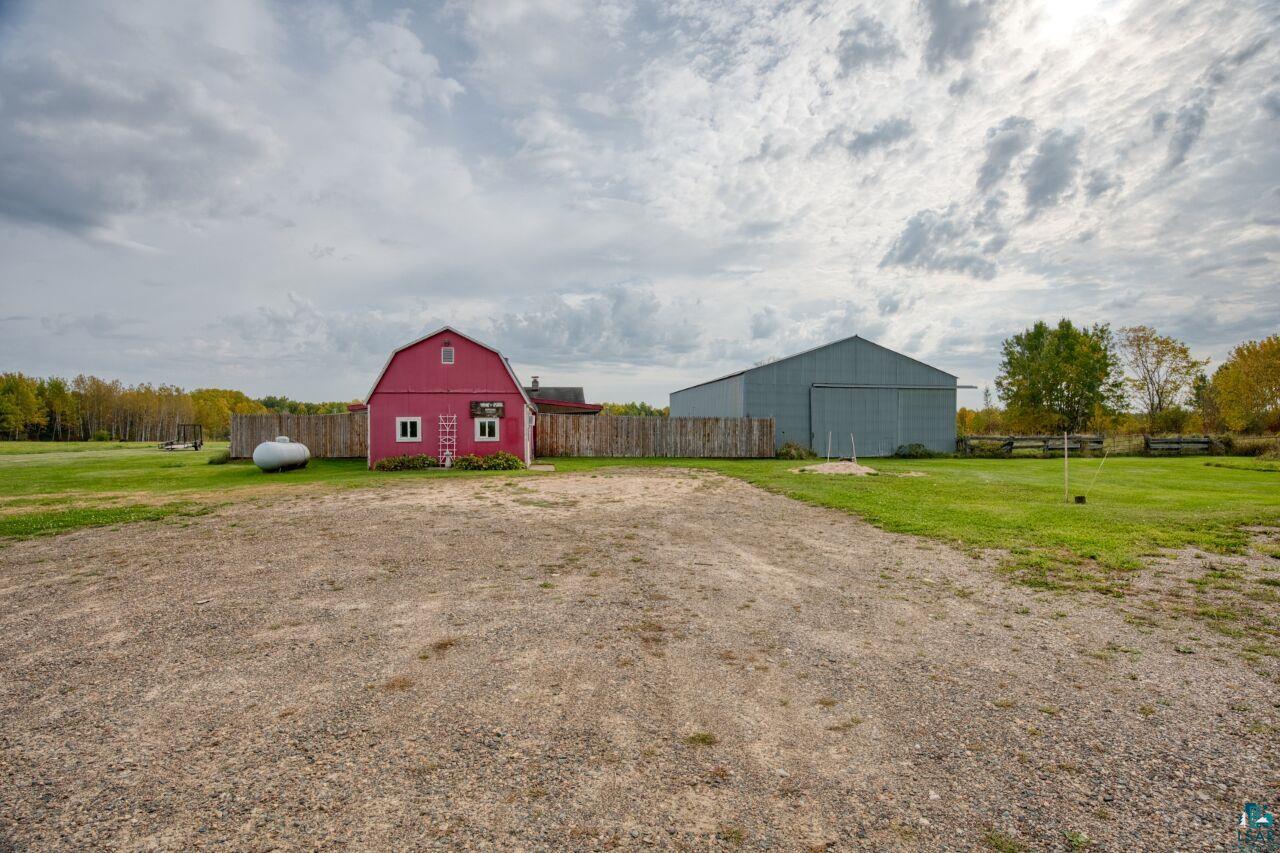 3360 North Leighton Road Hibbing, MN 55746 - Photo 46 of 60 View of yard featuring an outbuilding, a barn, a detached garage, and dirt driveway