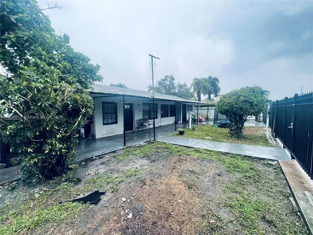 a view of a house with backyard and sitting area