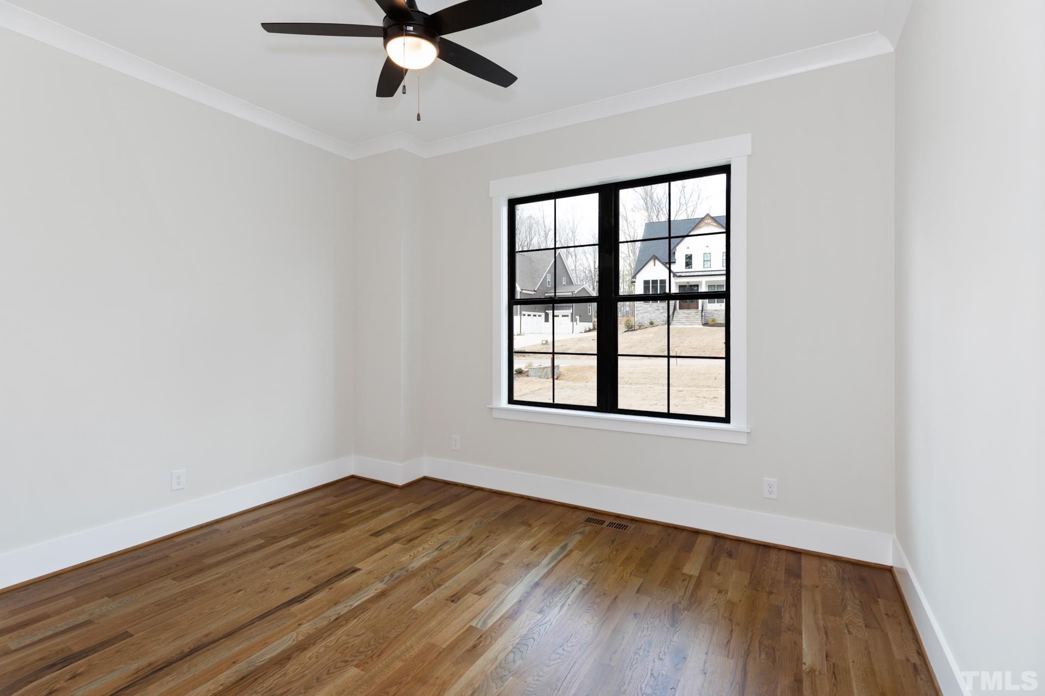 940 Harrison Ridge Road Wake Forest, NC 27587 - Photo 20 of 30 an empty room with wooden floor fan and windows