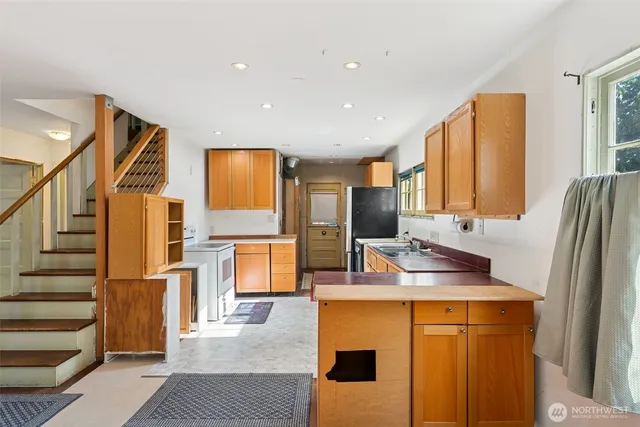 a kitchen with stainless steel appliances granite countertop a refrigerator and a stove top oven