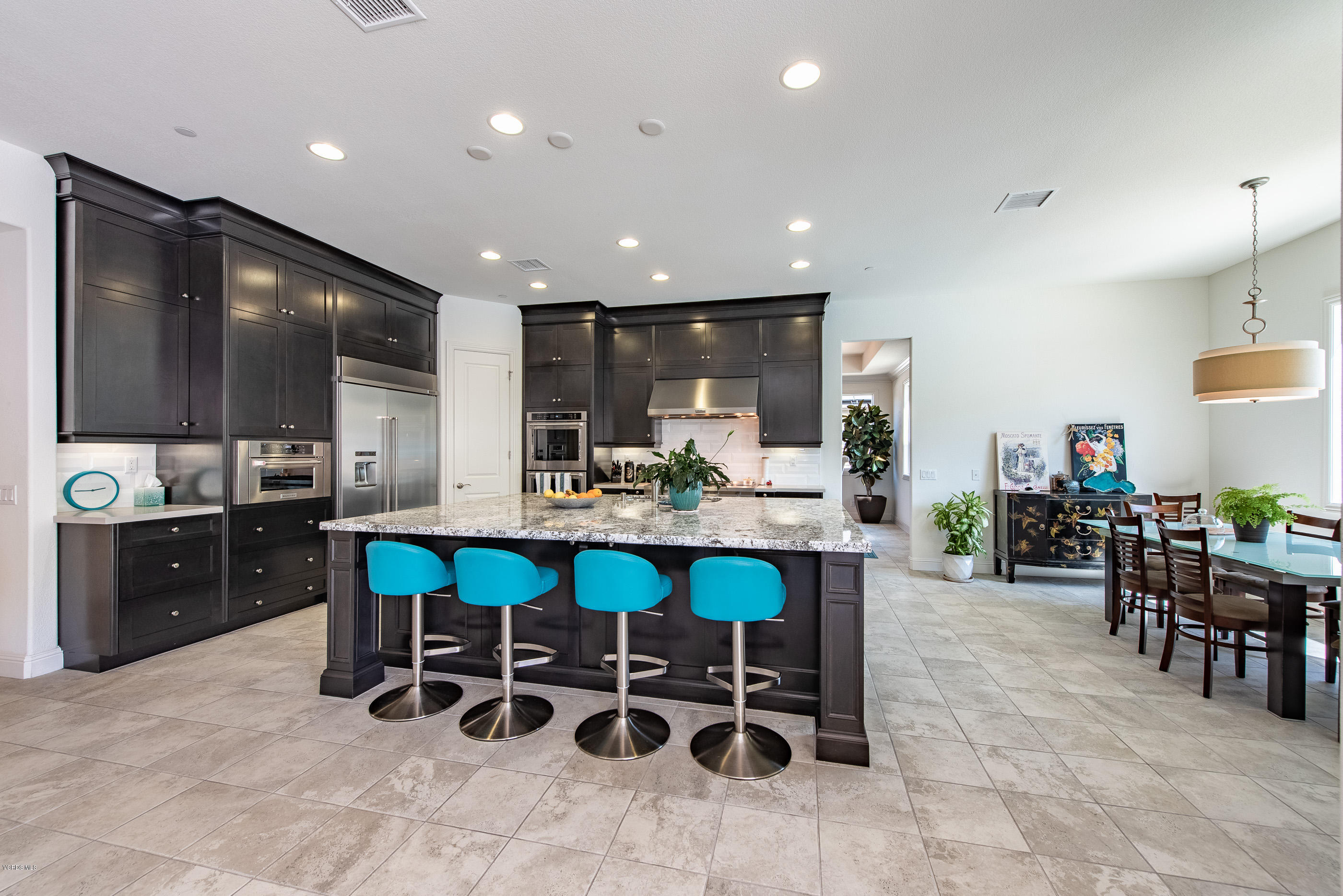 11276 Crenshaw Street Moorpark, CA 93021 - Photo 20 of 52 a kitchen with stainless steel appliances granite countertop table chairs sink and stove