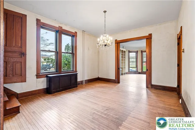 a view of a room with window wooden floor and chandelier