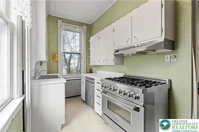 a kitchen with cabinets appliances and a window