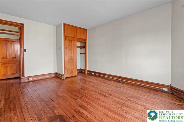 an empty room with wooden floor and closet