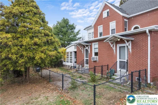 a kitchen with granite countertop a sink dishwasher stove and white cabinets with wooden floor