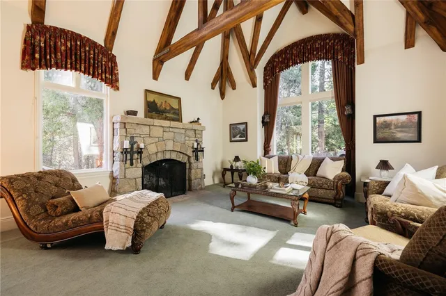 a living room with furniture fireplace and a large window