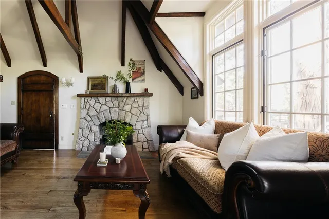 a living room with furniture a fireplace and a large window