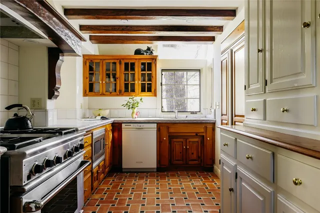 a kitchen with stainless steel appliances a sink stove and cabinets
