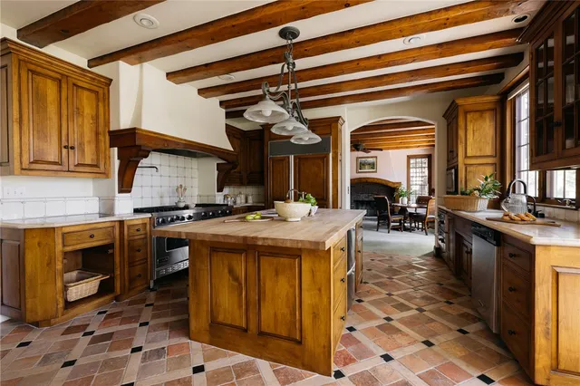 a kitchen with stainless steel appliances granite countertop a stove a sink and a microwave