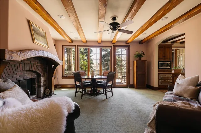 a living room with furniture a fireplace and a floor to ceiling window