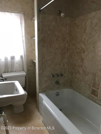 a bathroom with a toilet a sink and bathtub