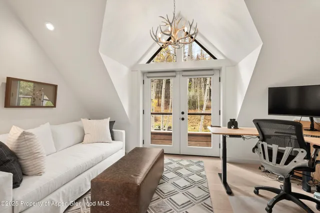 a living room with furniture a flat screen tv and a chandelier
