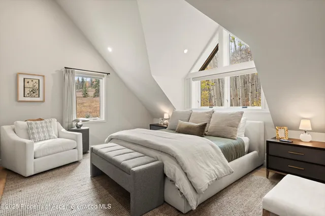 a bedroom with a bed a couch and a window