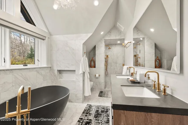 a bath room with a sink and a large mirror next to a window