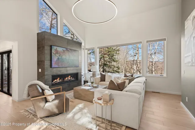 a living room with furniture a large window and a flat screen tv