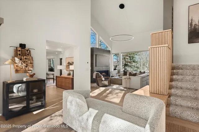 a living room with furniture a large window and a fireplace