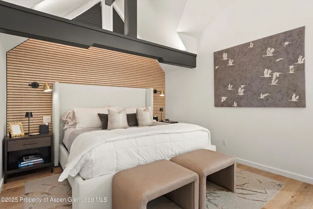 a bedroom with a bed and a painting on the wall