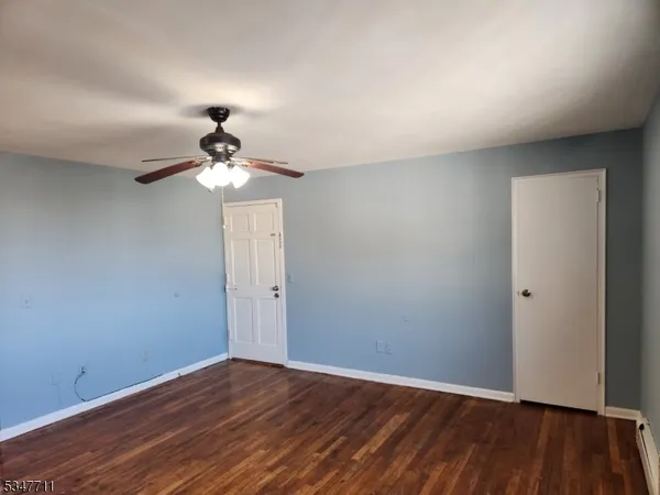 a view of an empty room with wooden floor