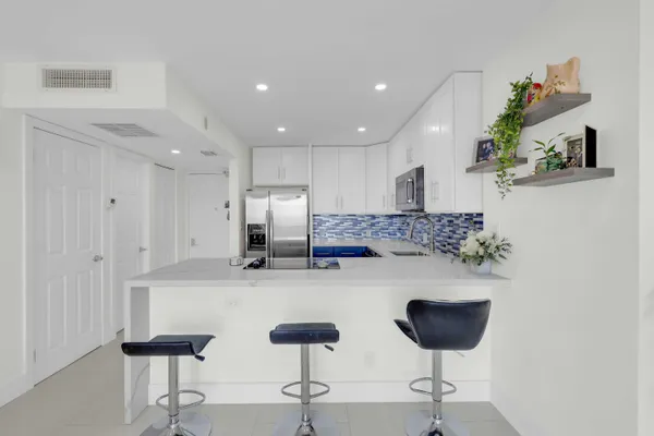 a kitchen with stainless steel appliances kitchen island granite countertop a dining table and chairs