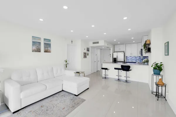 a living room with furniture and view of kitchen