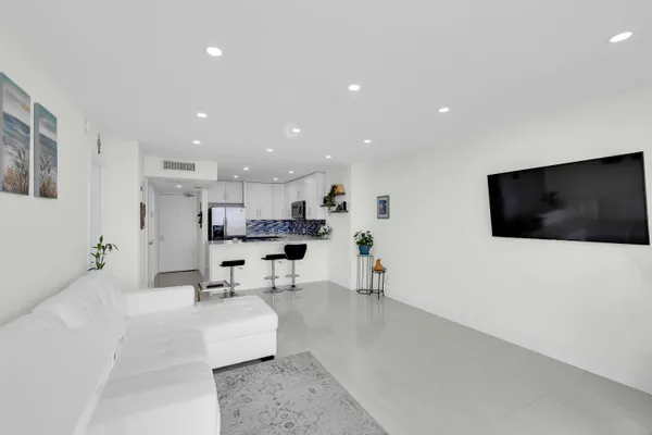 a living room with stainless steel appliances furniture a rug and a view