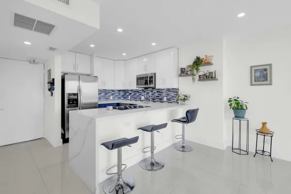 a kitchen with stainless steel appliances kitchen island granite countertop a refrigerator and a stove top oven