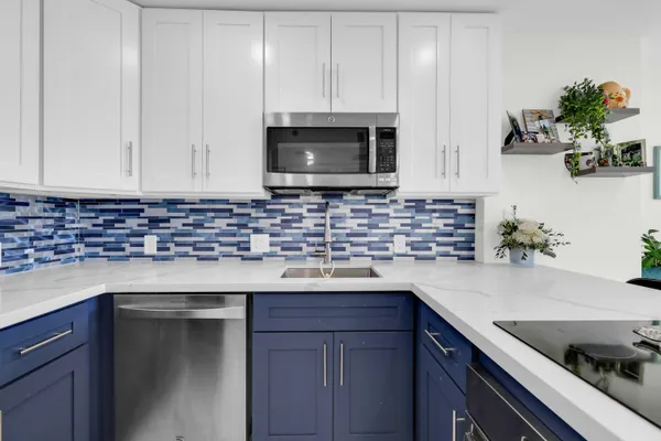 a kitchen with granite countertop white cabinets and a sink