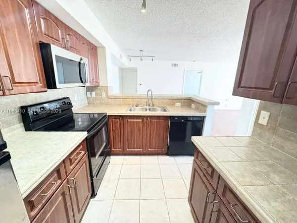 a kitchen with a sink a stove top oven a counter space and cabinets