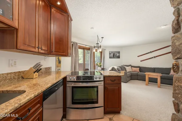 a kitchen with granite countertop a stove and a sink