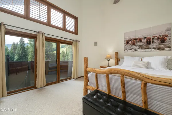 a bedroom with a bed and a dresser next to a window