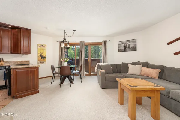 a living room with furniture a flat screen tv and a window