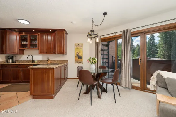 a kitchen with a table chairs refrigerator and cabinets