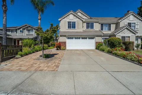 a front view of a house with yard and tree
