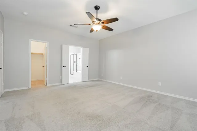 an empty room with closet and ceiling fan