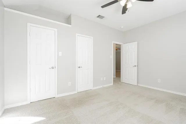 an empty room with a ceiling fan and a window