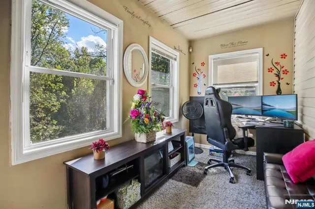 a view of a workspace with furniture and a window