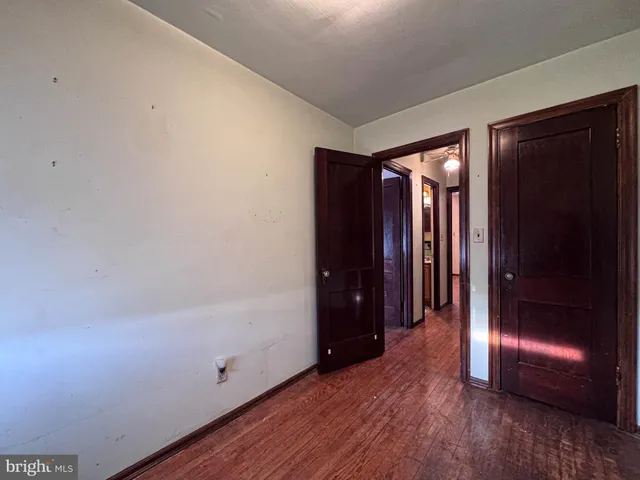 an empty room with wooden floor and entrance