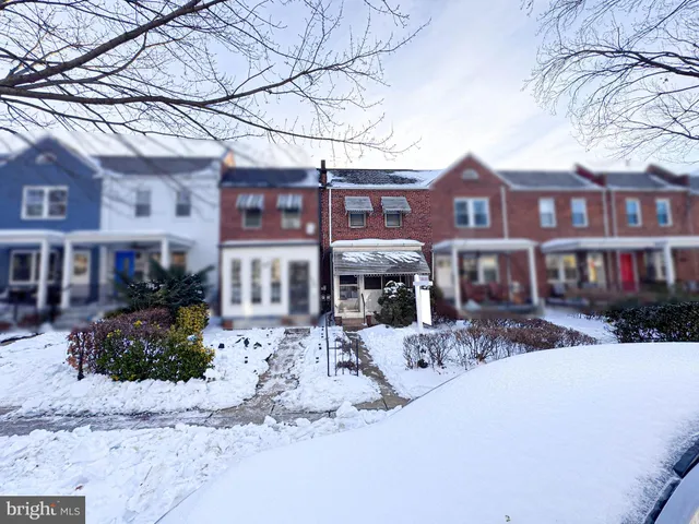 a front view of a building with large trees